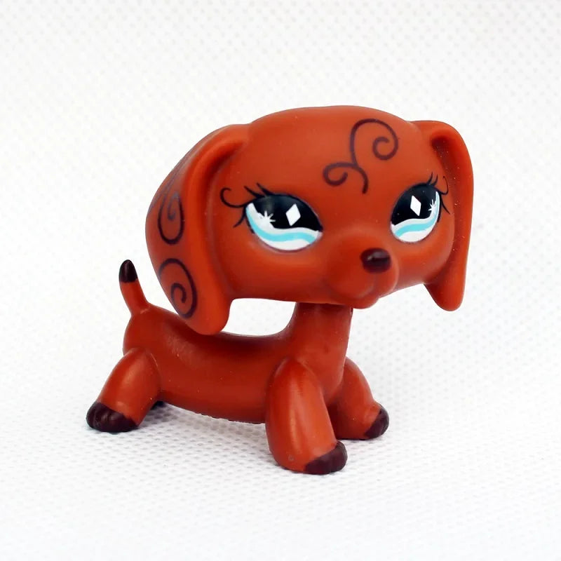 An orange dachshund bobblehead figurine with large blue eyes and decorative markings.