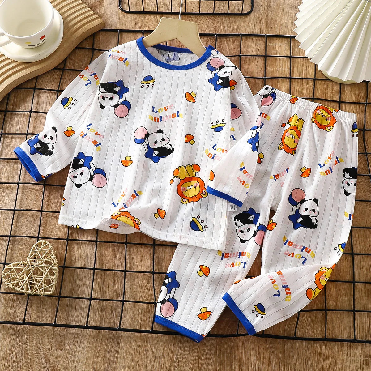 White long sleeve cotton pajama set for kids featuring cute animal patterns like cats and bears