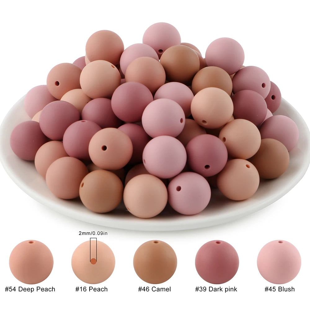 A collection of soft silicone round beads in various shades including peach, camel, pink, and blush.