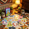 A collection of Cat Tarot cards laid out on a table, featuring various illustrations and tarot imagery.