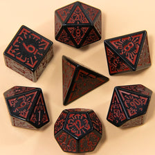 A set of seven fantasy carved polyhedral dice in black and red on a beige surface.
