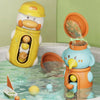 A yellow duck bath toy is shown next to a blue elephant bath toy, both featuring suction cup waterwheels in a clear tub.