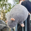 A gray plush rat with pink ears is being held by a person.