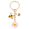 Gold-toned enamel keychain featuring a bee and a daisy flower design