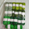 A pack of green and lime colored acrylic yarn skeins for knitting, crochet, and DIY crafts.
