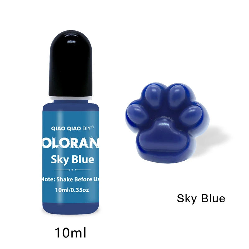 A small dark blue glass bottle of Sky Blue liquid pigment with a black cap and a purple paw print shape molded into the botto
