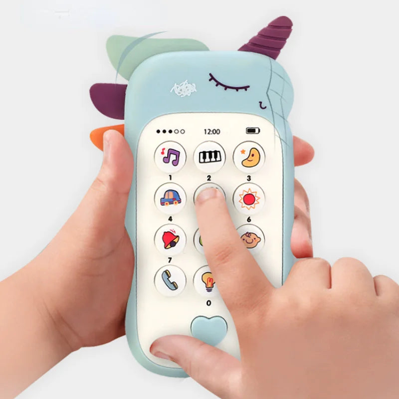 A hand is holding a light blue baby phone toy with purple ears and various buttons.