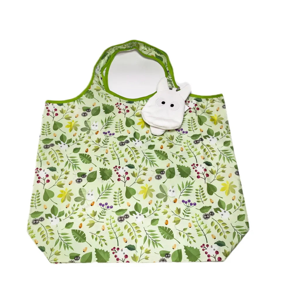 A white pygmy hippo plush toy with a green fabric pouch featuring a floral pattern.