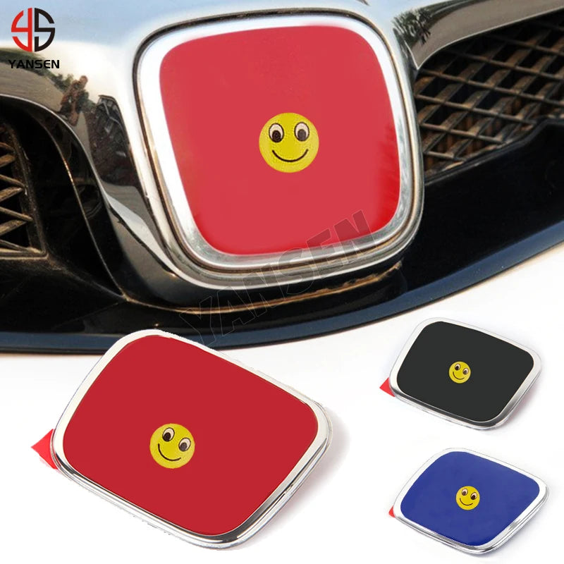 A red emblem car badge decal featuring a yellow smiling face on a black surface.