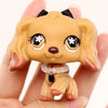 A small, light tan miniature pet animal figure with floppy ears and a collar is held in a person's hand.