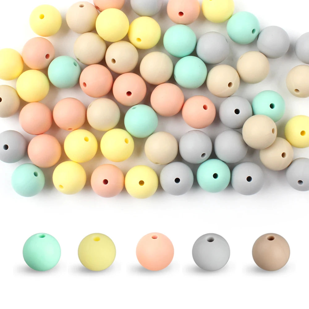 A collection of round silicone beads in various pastel colors including yellow, pink, green, and gray.