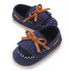 Navy baby first walker sneakers with brown fabric ties and a dinosaur print detail
