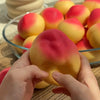 A hand is squeezing a squishy peach stress ball with yellow and pink coloring.