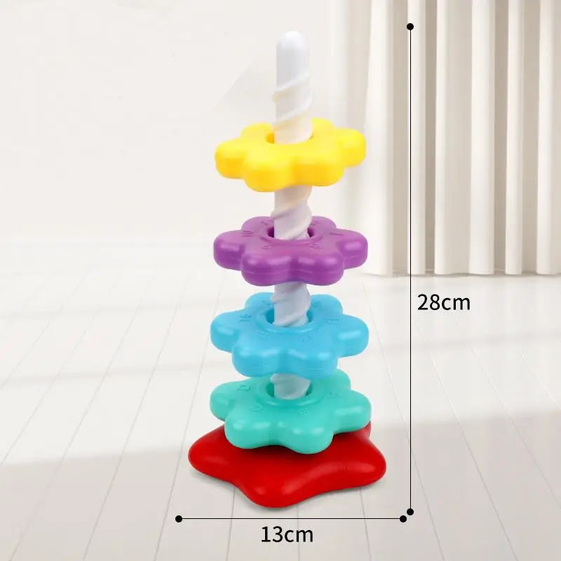 A colorful stacking tower made of plastic rings in yellow, purple, blue, and green, demonstrating motor skills.