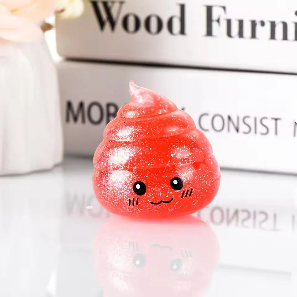 A bright red glitter squishy stress ball shaped like a smiling face, resting on a reflective surface.