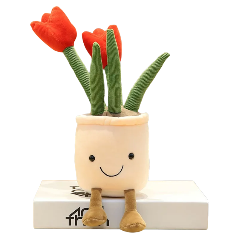A plush stuffed toy of a tulip succulent with green leaves and an orange flower, sitting on a white box.