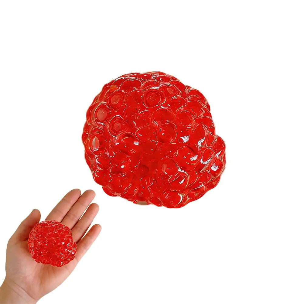 A bright red squishy bead stress ball is held in a person's hand.