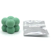 A pile of green candle dye chips for soy wax, beeswax, and paraffin wax.