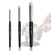 A set of 13 micro detail paint brushes in black and gold are shown next to a hand holding one brush.
