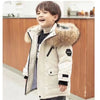 A young boy wearing a beige hooded winter jacket with a fluffy brown collar and black accents.