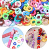 A close-up view of various colorful doughnut acrylic spacer beads for jewelry making, including pink, yellow, green, and purp