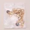 A set of gold-toned cartoon evil eye keychains packaged in a clear plastic bag.