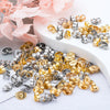 A collection of gold and silver earring stud bases with backs scattered on a white surface.