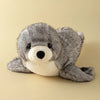 A gray seal plush toy with a black nose and white belly is shown against a light background.