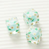 Three clear resin square beads with light blue and green floral designs for DIY jewelry making