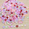 A pile of assorted pink, purple, and clear glass beads resembling tulip flowers.