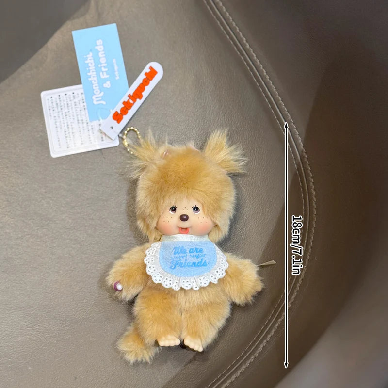 A small, fluffy, light brown Monchhichi plush toy is shown against a neutral background.