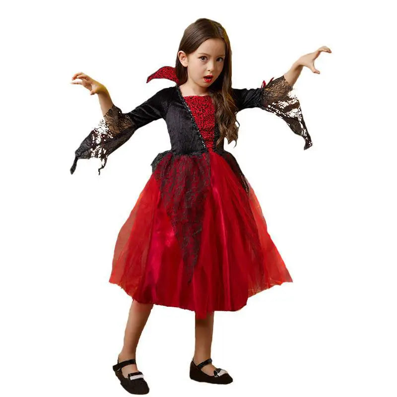 A young girl wearing a red and black vampire bat costume set with a cape and accessories.