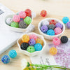 A collection of colorful rhinestone resin bayberry beads in various shades and sizes arranged on a wooden surface.