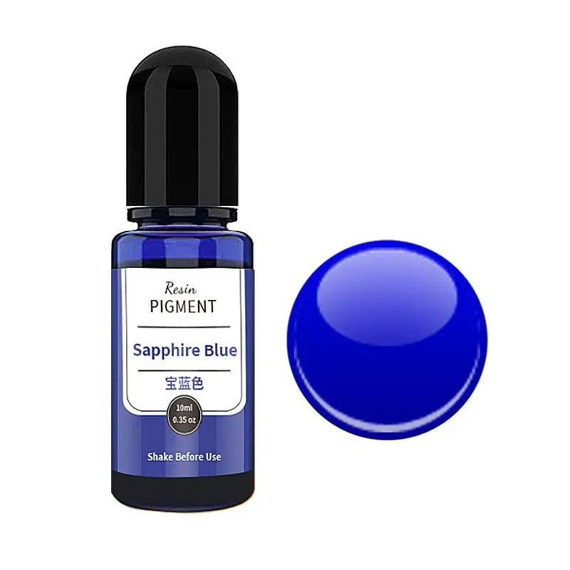 A dark glass bottle of Sapphire Blue resin pigment with a black cap next to a round blue pigment bead.