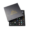 A black gift box containing a collection of various natural crystals and minerals.