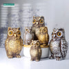 A collection of realistic owl garden statues in various sizes and shades of brown and gray.
