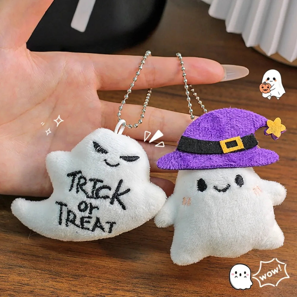 A set of Halloween plush keychains featuring a white ghost, a purple witch hat, and a yellow bat charm.