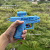 A hand holds a blue Plank Gun water gun, demonstrating how to press backward to spray water.