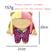 A plush doll with blonde and pink hair wearing a purple patterned shirt.