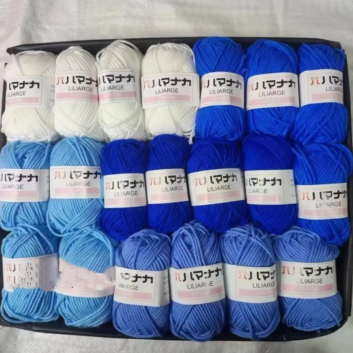 A pack of blue and white yarn skeins for knitting, crochet, and DIY crafts.