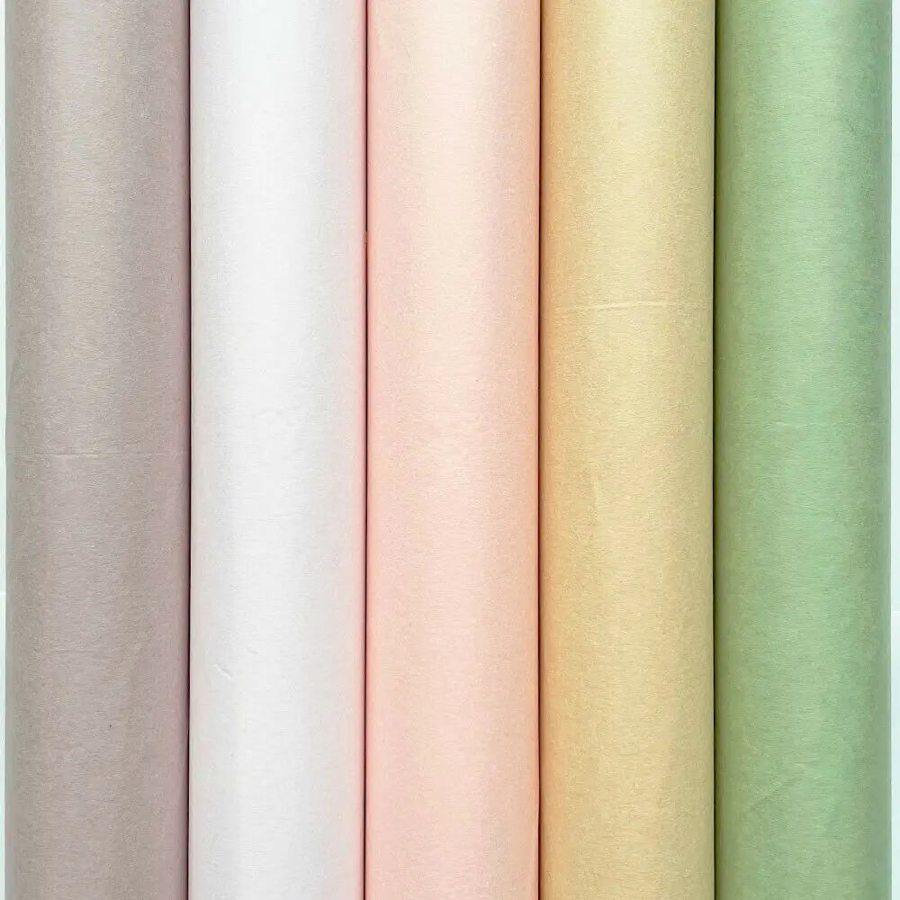 A vertical stack of twenty translucent tissue paper sheets in soft pastel shades including beige, pink, yellow, and light gre