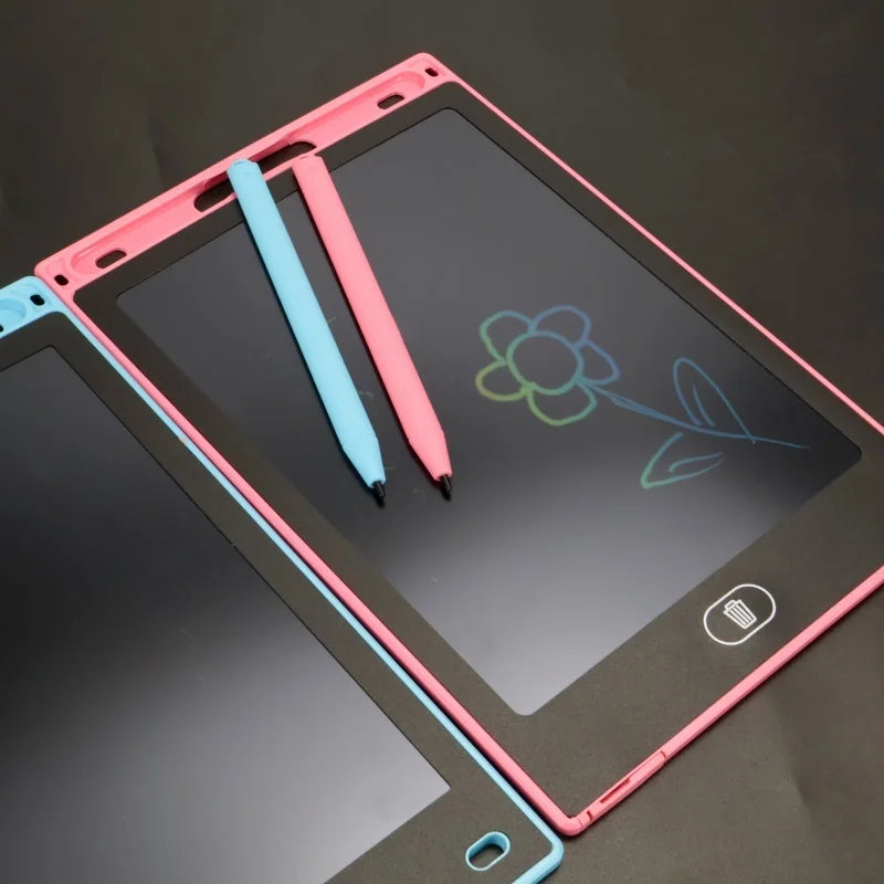 A pink and blue LCD writing tablet with two pens is shown on a dark surface.