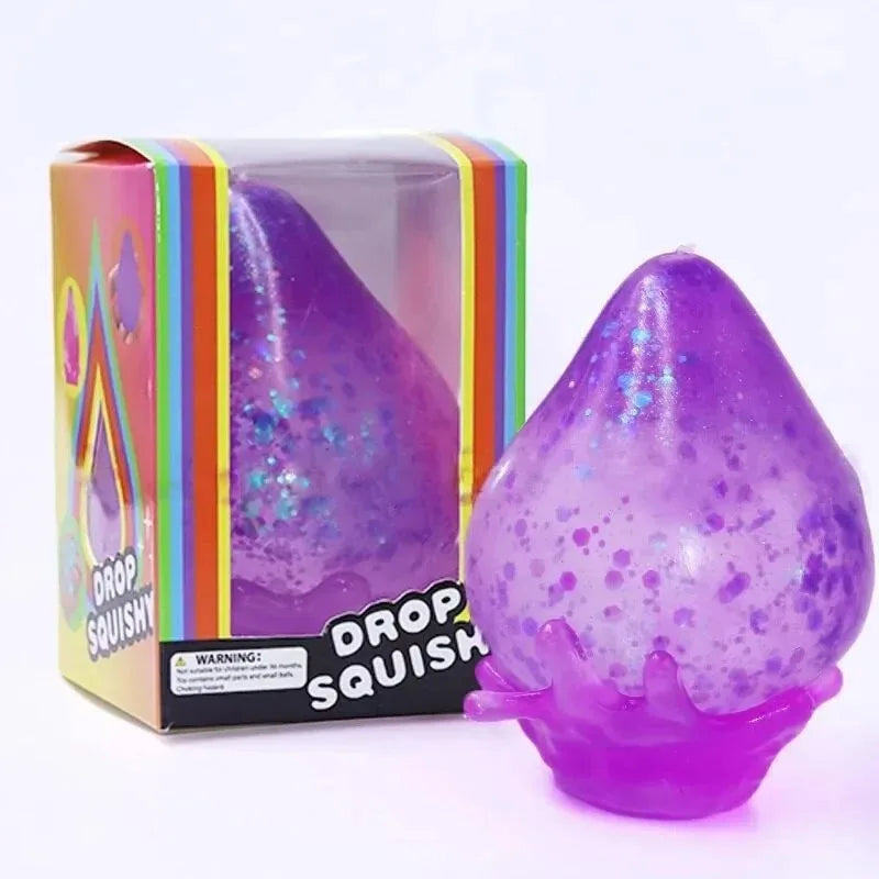 A purple squishy toy shaped like a raindrop is shown in its packaging.