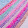 Rainbow faceted crystal rondelle beads in pink, blue, and purple stacked in a strand