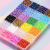 A clear plastic box filled with various colors of flat-back rhinestones for DIY crafts.