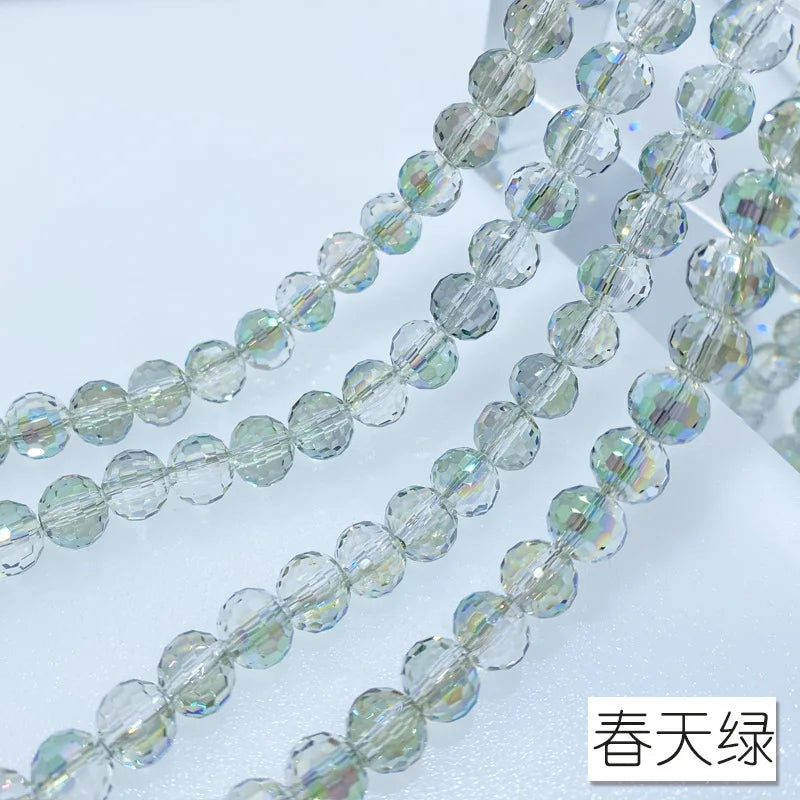 A close-up of a strand of clear, iridescent Austrian crystal beads with AB coating.