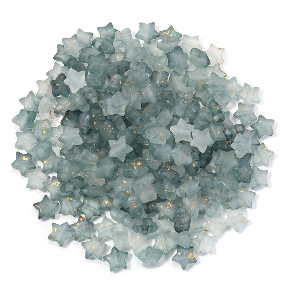 A pile of small, transparent, star-shaped acrylic beads in a bluish-green color.