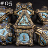 A set of five polyhedral metal dice in gold and blue tones displayed against a dark background.