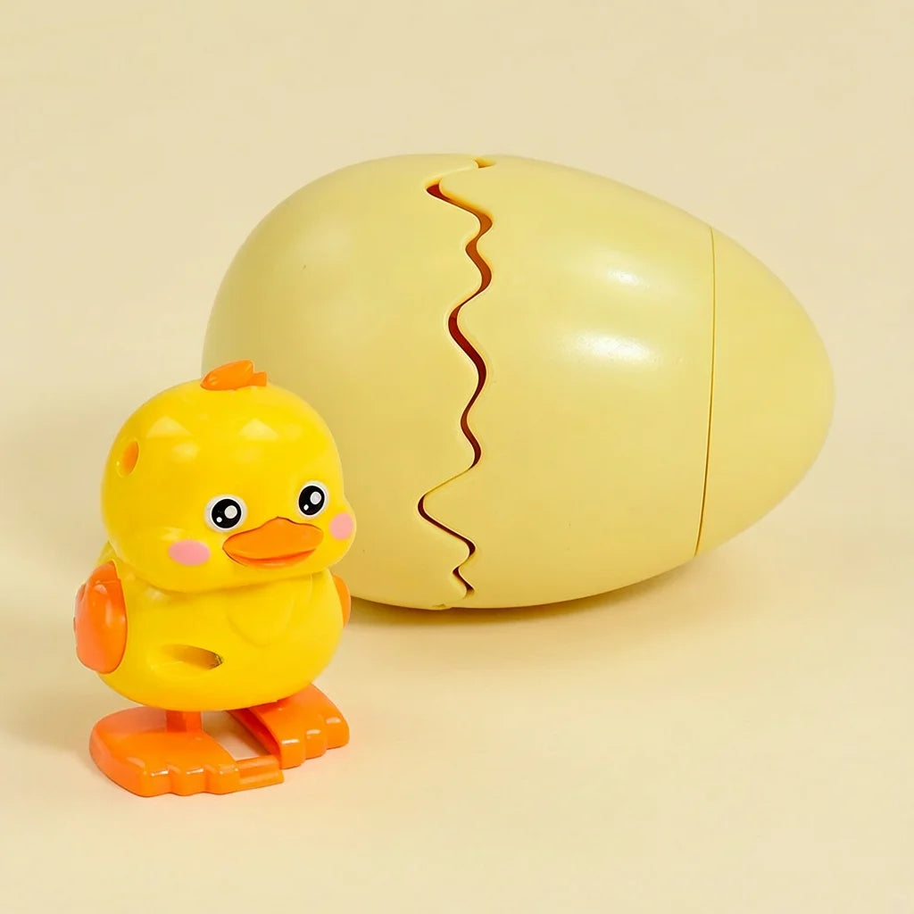 A yellow wind-up bouncing chick toy is shown next to its cracked shell.
