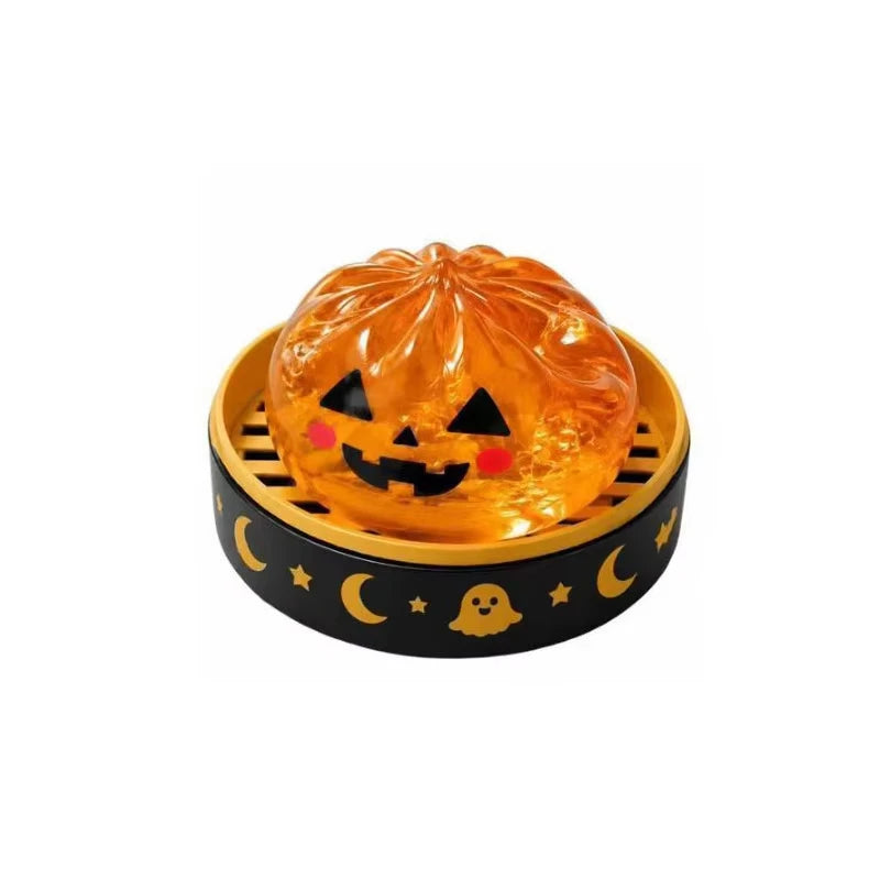 An orange glitter pumpkin Halloween squishy fidget toy set with an eyeball and skull inside a wooden tray